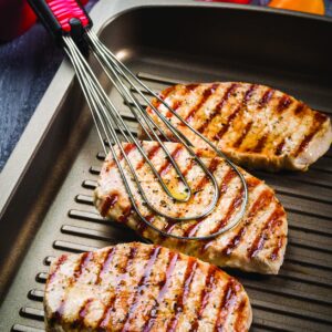 Pince et fouet Foodie Börner retournant des grillades sur une plancha